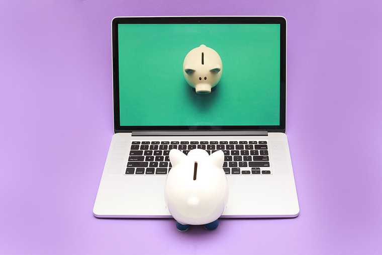 A laptop with a piggy bank