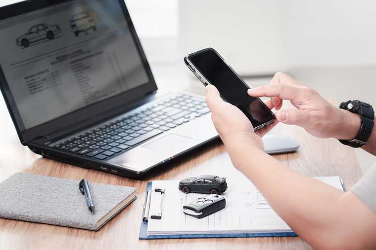 A laptop, a phone and two car keys on the table